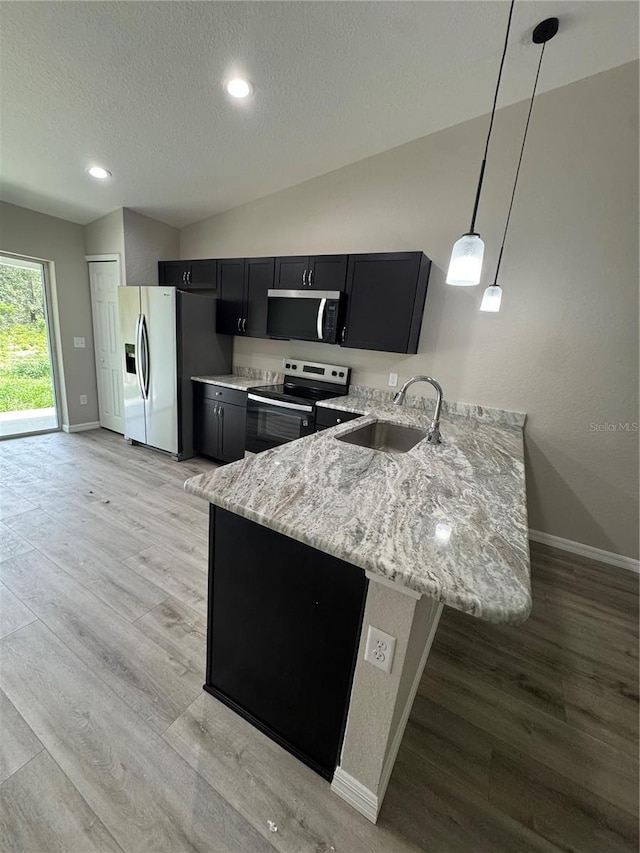 15099 SW 29th Terrace Rd, Ocala, FL 34473 - kitchen with a sink, stainless steel appliances, dark cabinetry, baseboards, and a textured ceiling