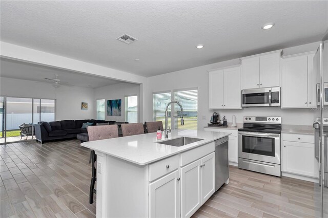9312 SW 58th Cir, Ocala, FL 34476 - kitchen with appliances with stainless steel finishes, a sink, light wood-style floors, light countertops, and white cabinetry