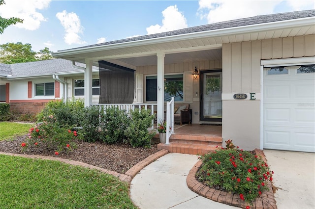 8645 SW 94th Ln Unit E, Ocala, FL 34481 - doorway to property with an attached garage, a shingled roof, and covered porch