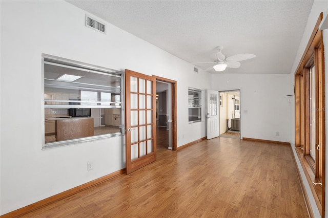8645 SW 94th Ln Unit E, Ocala, FL 34481 - unfurnished living room featuring visible vents, baseboards, ceiling fan, and wood finished floors