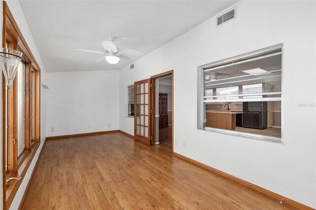 8645 SW 94th Ln Unit E, Ocala, FL 34481 - unfurnished room with visible vents, baseboards, a ceiling fan, and wood finished floors