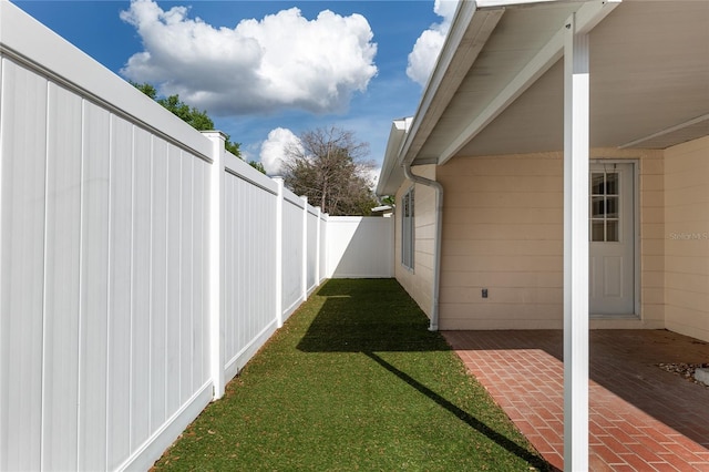 8645 SW 94th Ln Unit E, Ocala, FL 34481 - view of property exterior with a patio, a fenced backyard, and a lawn