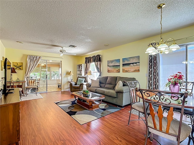 916 Cancun Ct, Lady Lake, FL 32159 - living area with visible vents, a textured ceiling, wood finished floors, and ceiling fan with notable chandelier