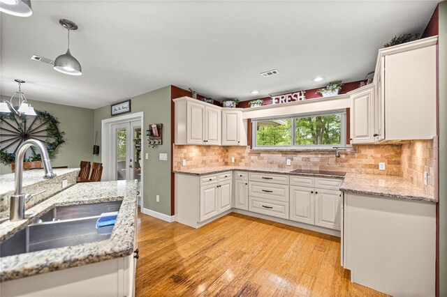 5118 SW 197th Ter, Dunnellon, FL 34431 - kitchen featuring a sink, light wood finished floors, white cabinets, tasteful backsplash, and recessed lighting