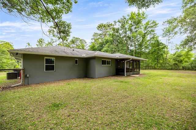 5118 SW 197th Ter, Dunnellon, FL 34431 - back of house with a sunroom, stucco siding, a lawn, and central AC unit