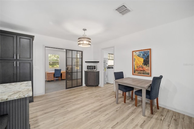 6549 NW 65th Pl, Ocala, FL 34482 - dining room featuring baseboards, washer / clothes dryer, light wood-style flooring, and visible vents
