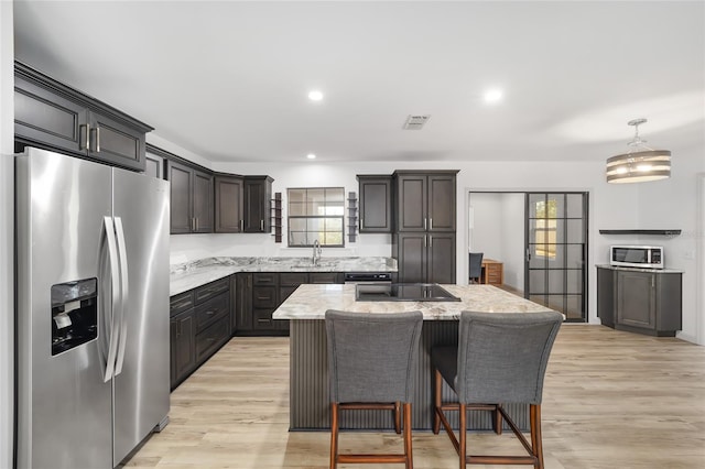 6549 NW 65th Pl, Ocala, FL 34482 - kitchen featuring visible vents, a center island, appliances with stainless steel finishes, and light wood-type flooring