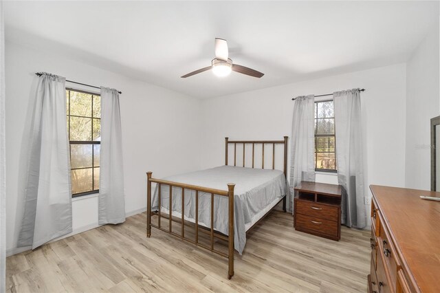 6549 NW 65th Pl, Ocala, FL 34482 - bedroom featuring multiple windows, light wood-type flooring, baseboards, and a ceiling fan