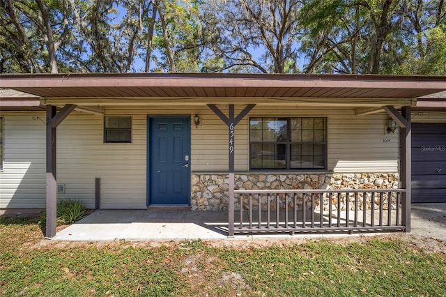 6549 NW 65th Pl, Ocala, FL 34482 - property entrance featuring stone siding and a porch
