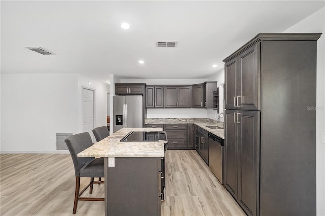 6549 NW 65th Pl, Ocala, FL 34482 - kitchen featuring visible vents, a kitchen bar, appliances with stainless steel finishes, and a kitchen island