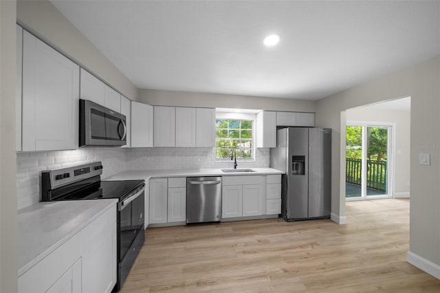 341 SE 53rd Ct, Ocala, FL 34480 - kitchen with light countertops, backsplash, a sink, light wood-style flooring, and appliances with stainless steel finishes
