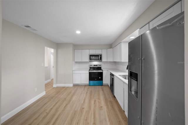 341 SE 53rd Ct, Ocala, FL 34480 - kitchen with light countertops, visible vents, tasteful backsplash, appliances with stainless steel finishes, and white cabinetry