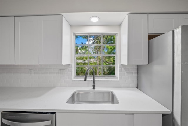 341 SE 53rd Ct, Ocala, FL 34480 - kitchen with white cabinetry, a sink, stainless steel appliances, and backsplash
