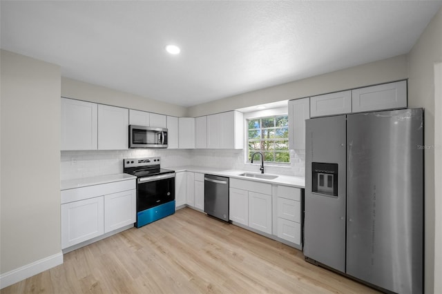 341 SE 53rd Ct, Ocala, FL 34480 - kitchen with light countertops, light wood-style flooring, stainless steel appliances, a sink, and backsplash