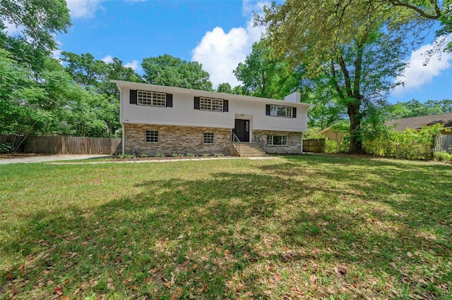 341 SE 53rd Ct, Ocala, FL 34480 - bi-level home featuring fence, stone siding, entry steps, a front yard, and a chimney