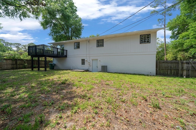 341 SE 53rd Ct, Ocala, FL 34480 - rear view of house with cooling unit, a fenced backyard, a wooden deck, and a lawn