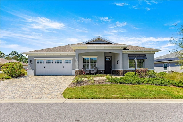 9342 SW 102nd Terrace Rd, Ocala, FL 34481 - view of front facade with a front yard, stone siding, stucco siding, an attached garage, and decorative driveway