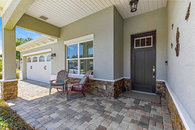 9342 SW 102nd Terrace Rd, Ocala, FL 34481 - property entrance featuring stucco siding, stone siding, and a garage