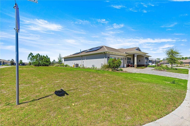 9342 SW 102nd Terrace Rd, Ocala, FL 34481 - view of front of house featuring decorative driveway, an attached garage, a front yard, solar panels, and stucco siding