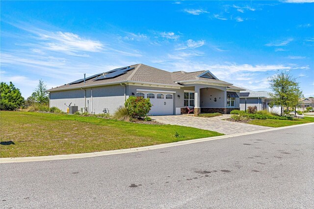 9342 SW 102nd Terrace Rd, Ocala, FL 34481 - view of front of home featuring stucco siding, an attached garage, decorative driveway, a front yard, and solar panels