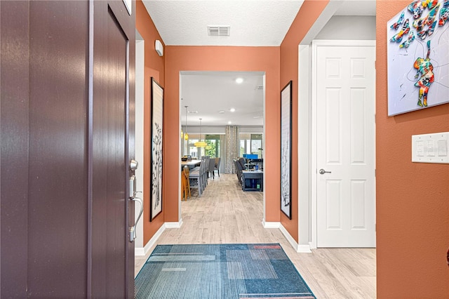 9342 SW 102nd Terrace Rd, Ocala, FL 34481 - entrance foyer with baseboards, visible vents, light wood-style flooring, and a textured ceiling