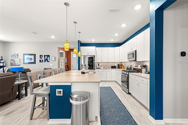 9342 SW 102nd Terrace Rd, Ocala, FL 34481 - kitchen featuring a kitchen breakfast bar, open floor plan, light wood-type flooring, stainless steel appliances, and a sink