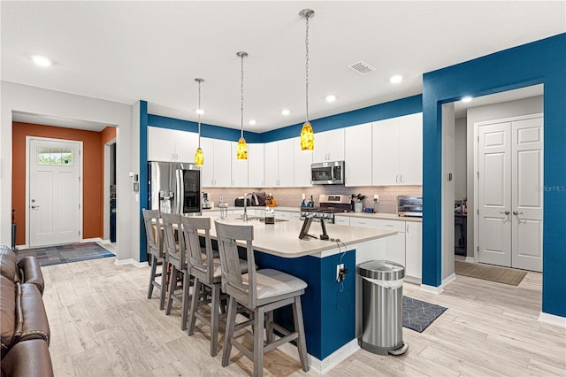 9342 SW 102nd Terrace Rd, Ocala, FL 34481 - kitchen featuring a kitchen breakfast bar, light countertops, a sink, visible vents, and appliances with stainless steel finishes