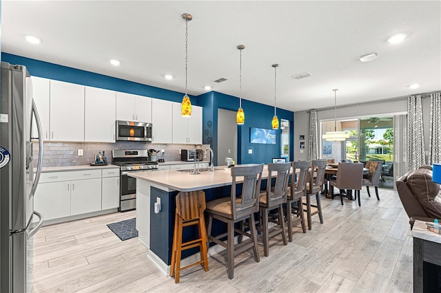 9342 SW 102nd Terrace Rd, Ocala, FL 34481 - kitchen featuring light countertops, light wood-type flooring, decorative backsplash, a sink, and appliances with stainless steel finishes