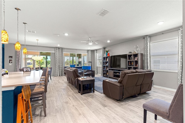 9342 SW 102nd Terrace Rd, Ocala, FL 34481 - living room with a textured ceiling, light wood-style flooring, visible vents, and ceiling fan