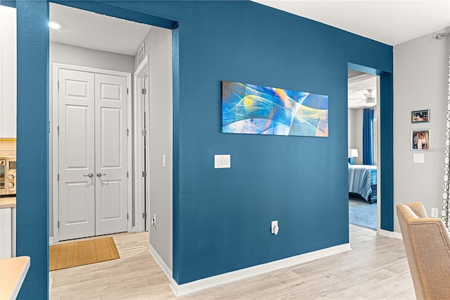 9342 SW 102nd Terrace Rd, Ocala, FL 34481 - corridor featuring a textured ceiling, baseboards, and light wood-type flooring