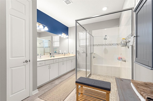 9342 SW 102nd Terrace Rd, Ocala, FL 34481 - bathroom featuring a sink, a stall shower, visible vents, double vanity, and wood finished floors