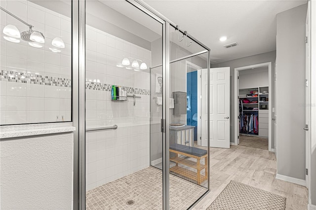 9342 SW 102nd Terrace Rd, Ocala, FL 34481 - bathroom with visible vents, a shower stall, baseboards, wood finished floors, and a spacious closet