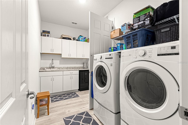 9342 SW 102nd Terrace Rd, Ocala, FL 34481 - laundry area featuring separate washer and dryer, a textured ceiling, a sink, light wood finished floors, and indoor wet bar