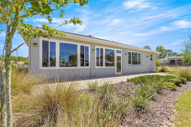 9342 SW 102nd Terrace Rd, Ocala, FL 34481 - rear view of property featuring stucco siding and a patio area