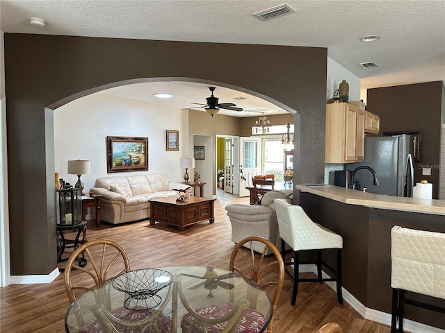 9053 SW 103rd Ave, Ocala, FL 34481 - living room with arched walkways, ceiling fan, light wood-style floors, a textured ceiling, and baseboards