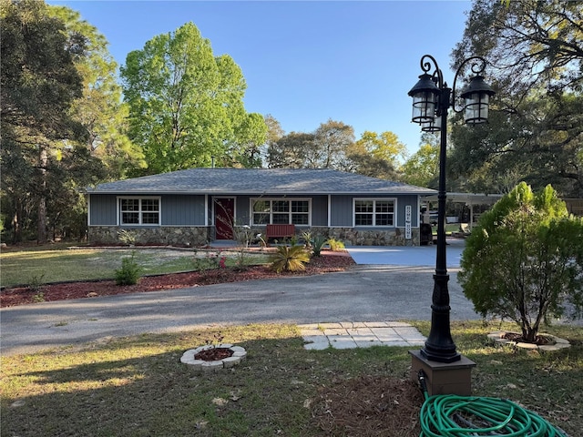 4540 W Sandy Hill St, Lecanto, FL 34461 - ranch-style home featuring stone siding, a front yard, a porch, and asphalt driveway