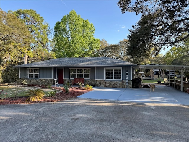 4540 W Sandy Hill St, Lecanto, FL 34461 - view of front of house featuring stone siding, an attached carport, driveway, and a shingled roof