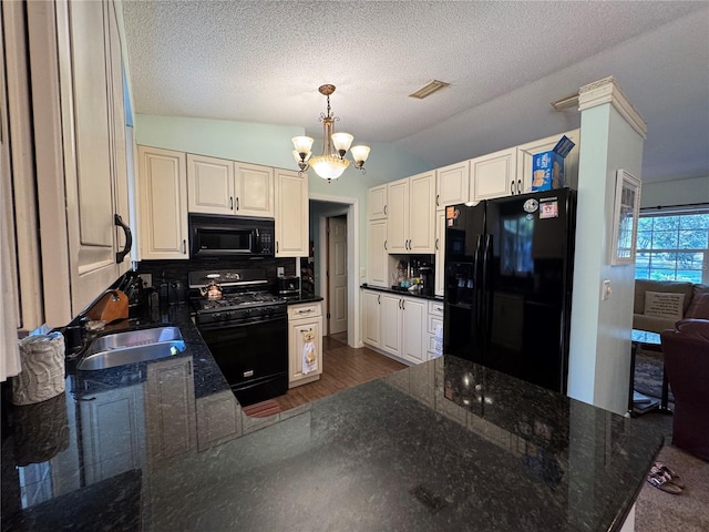4540 W Sandy Hill St, Lecanto, FL 34461 - kitchen with black appliances, a sink, a chandelier, tasteful backsplash, and vaulted ceiling