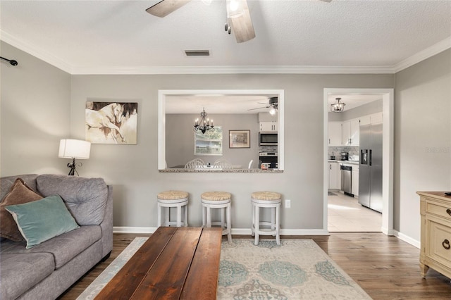 6830 NW 62nd Pl, Ocala, FL 34482 - living area with light wood-style flooring, ceiling fan with notable chandelier, crown molding, and visible vents