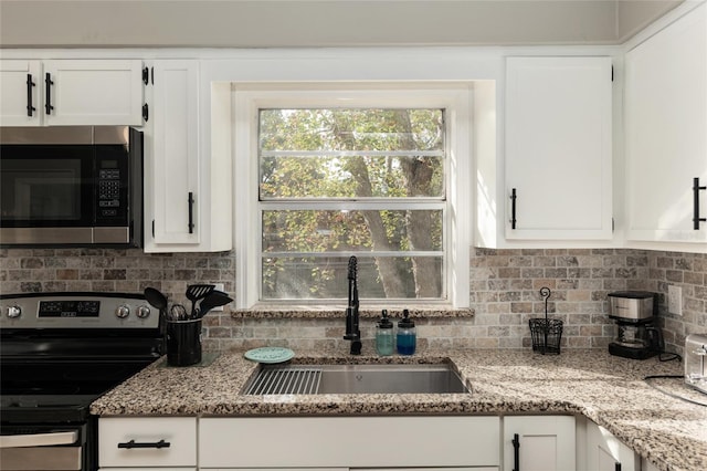 6830 NW 62nd Pl, Ocala, FL 34482 - kitchen featuring stainless steel appliances, backsplash, a sink, light stone counters, and white cabinets