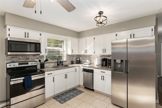 6830 NW 62nd Pl, Ocala, FL 34482 - kitchen with white cabinetry, decorative backsplash, a sink, ceiling fan, and appliances with stainless steel finishes