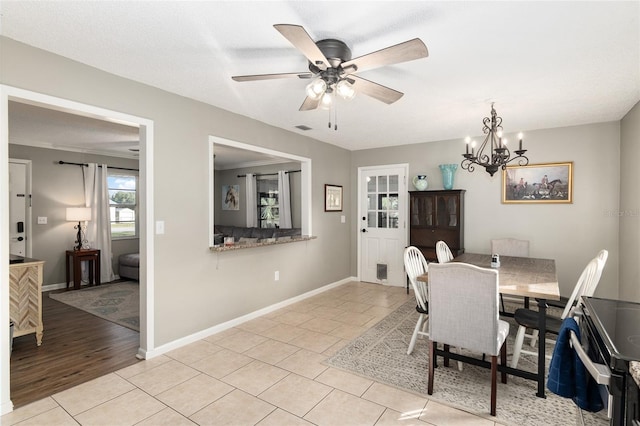 6830 NW 62nd Pl, Ocala, FL 34482 - dining room featuring light tile patterned floors, ceiling fan with notable chandelier, and baseboards