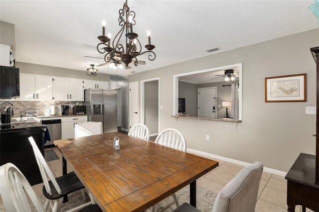 6830 NW 62nd Pl, Ocala, FL 34482 - dining area featuring a textured ceiling, baseboards, light tile patterned floors, ceiling fan with notable chandelier, and visible vents