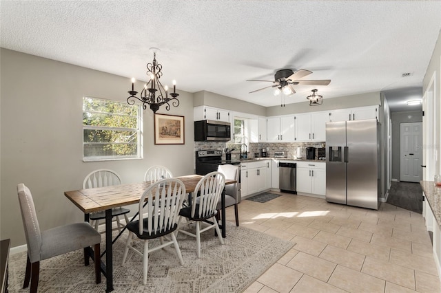 6830 NW 62nd Pl, Ocala, FL 34482 - dining space featuring light tile patterned flooring, ceiling fan with notable chandelier, visible vents, and a textured ceiling