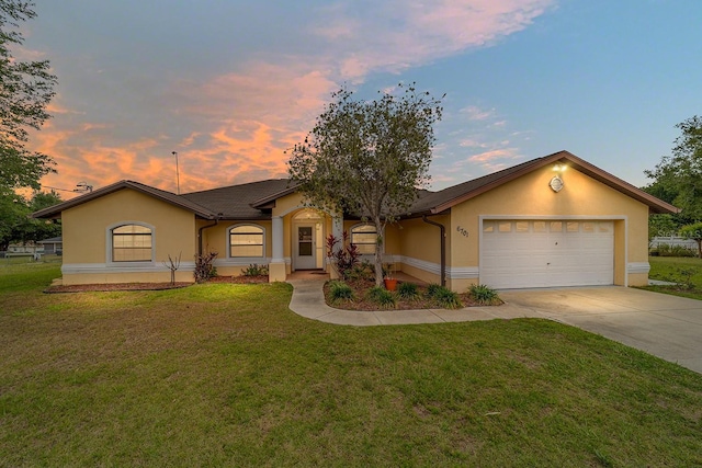 ranch-style home featuring stucco siding, driveway, a garage, and a front yard