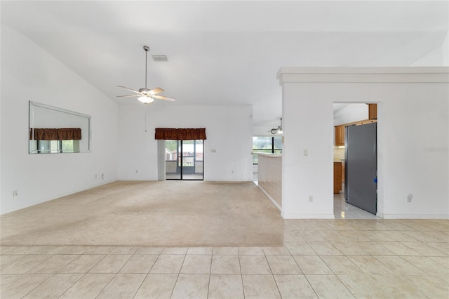 empty room featuring light colored carpet, light tile patterned flooring, a ceiling fan, baseboards, and high vaulted ceiling