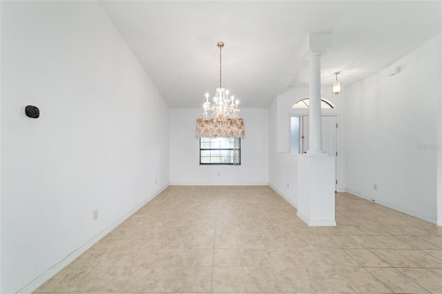empty room featuring a chandelier, light tile patterned floors, and baseboards