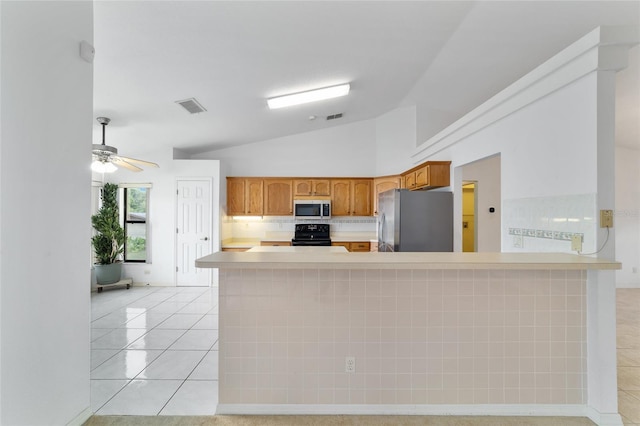 kitchen featuring freestanding refrigerator, vaulted ceiling, black range with electric stovetop, light countertops, and light tile patterned flooring