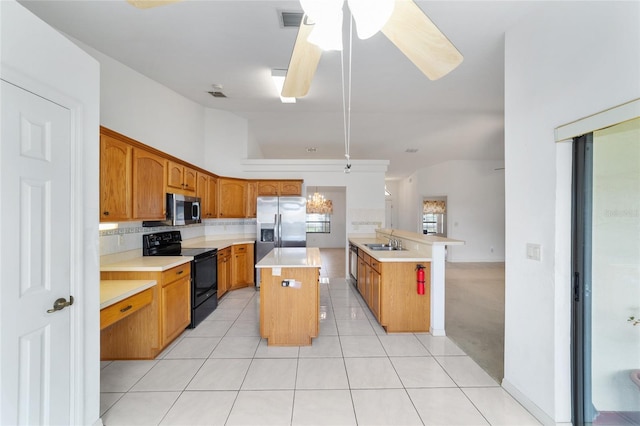 kitchen featuring stainless steel appliances, a center island, a sink, light countertops, and ceiling fan