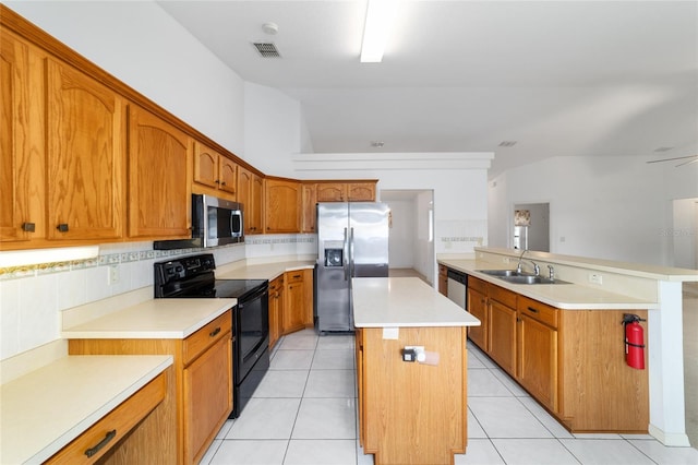 kitchen with appliances with stainless steel finishes, a sink, a kitchen island, light countertops, and lofted ceiling
